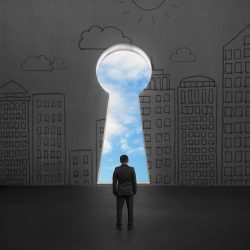 Man standing in front of key door on concrete wall